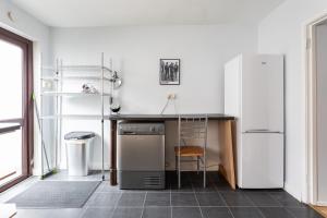 a kitchen with a refrigerator and a table with a chair at Belfast City - 3 Bedroom Cosy Home - Walking Distance to City in Belfast