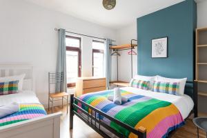 1 dormitorio con 2 camas y paredes azules en Belfast City - 3 Bedroom Cosy Home - Walking Distance to City, en Belfast