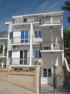 a tall white building with balconies on the side of it at Apartments Pekic in Bar