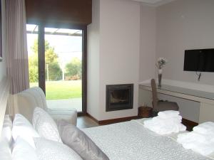a living room with two beds and a fireplace at Bosque da Harmonia in Arco de Baúlhe