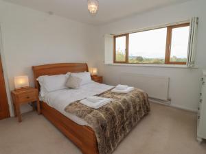 1 dormitorio con 1 cama con 2 toallas en The Firs Retreat, en Cheltenham