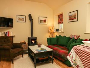 a living room with a green couch and a fireplace at The Homestead Lodge in Windermere