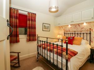 1 dormitorio con cama y ventana en The Homestead Lodge en Windermere