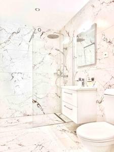 a white bathroom with a toilet and a shower at Wesley House in Kandersteg