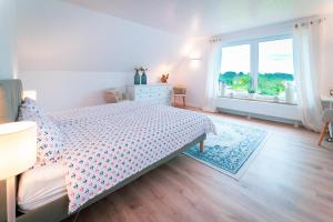 ein Schlafzimmer mit einem Bett und einem großen Fenster in der Unterkunft Ferienhaus Meergefühl in Neukirchen