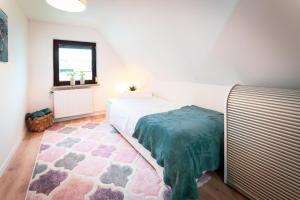ein Schlafzimmer mit einem Bett, einem Fenster und einem Teppich in der Unterkunft Ferienhaus Meergefühl in Neukirchen