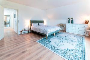 ein Schlafzimmer mit einem Bett und einem Teppich in der Unterkunft Ferienhaus Meergefühl in Neukirchen