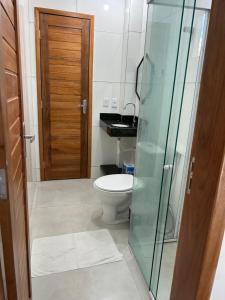 a bathroom with a toilet and a glass shower door at Chaleville Barrinha in Barrinha +18 photos