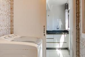 una lavanderia bianca con lavatrice e asciugatrice di Apto 3 quartos na quadra do Mar UW7300 a Piçarras