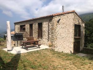 a stone cottage with a picnic table and a bench at Cal Mureu in Pardines