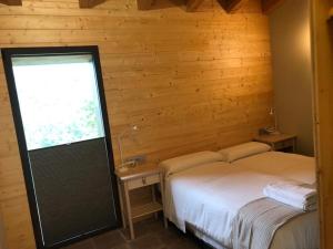 1 dormitorio con 2 camas y ventana. en Cal Mureu en Pardines