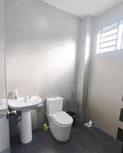 ein Badezimmer mit einem weißen WC und einem Waschbecken in der Unterkunft Marvelous Homestay SP Kedah in Sungai Petani