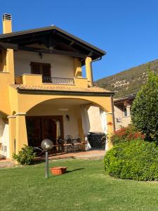 奇亚La Casa sulla collina "Baccu e Idda"的黄色的房子,带庭院的庭院