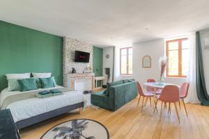 a bedroom with a bed and a couch and a table at Casalova07 Logements Safari Parc Bord du Rhône in Serrières