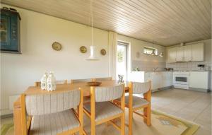 a kitchen and dining room with a wooden table and chairs at 3 Bedroom Amazing Home In Hurup Thy in Doverodde