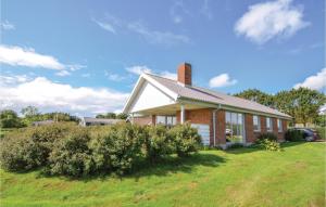 a brick house with a chimney on top of a yard at 3 Bedroom Amazing Home In Hurup Thy in Doverodde