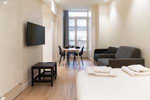 a room with a bed and a table and a tv at Croix Paquet - Appartements à Lyon in Lyon