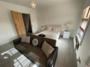a living room with a couch and a bed at A lovely Three bedroom house in Windsor in Windsor