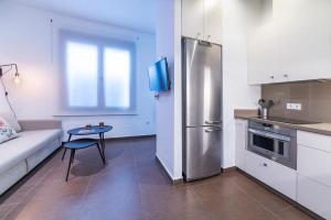 a kitchen with a stainless steel refrigerator and a table at AlohaMundi Campana II in Seville