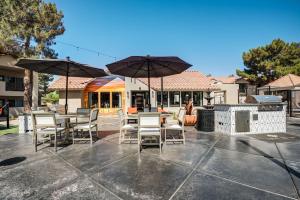 eine Terrasse mit Tischen, Stühlen und Sonnenschirmen in der Unterkunft Spacious Modern Apartments at Hideaway North Scottsdale close to Kierland Commons in Scottsdale