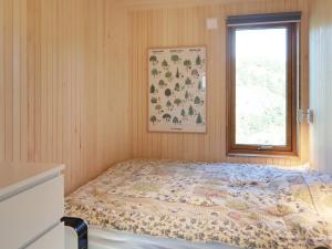 um quarto com uma cama e uma janela em Holiday home Søndeled em Søndeled