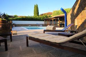 un patio con 2 sedie a sdraio e una piscina di La Bella Toscana a Monsummano