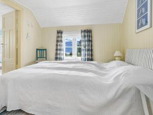 Una cama blanca grande en una habitación con ventana. en 6 person holiday home in AVERØY-By Traum, en Stein 44 fotos más