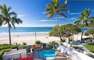 a view of a beach with a swimming pool and palm trees at The Breakers, Apartment 4 in Noosa Heads