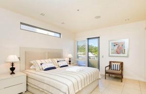 a bedroom with a bed and a chair and a window at The Breakers, Apartment 4 in Noosa Heads