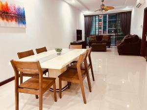 een eetkamer en een woonkamer met een tafel en stoelen bij Imperial Suite At Boulevard in Kuching