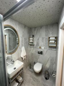y baño con lavabo, aseo y espejo. en TAKSİM HAVANA HOTEL SUİTES en Estambul