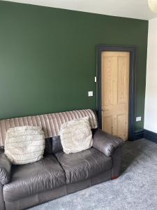 a brown leather couch in a room with a door at Wilson 74 in Darlington