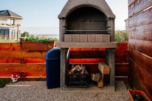 un horno de pizza al aire libre con un cubo de basura azul en Spacious studio near lake en Năvodari