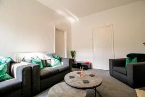 een woonkamer met een bank en een tafel bij Lovely 3BR Flat in the Heart of South Shields in South Shields