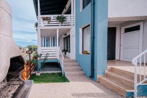 a blue building with stairs and a door at 1 bedroom Lake House in Năvodari