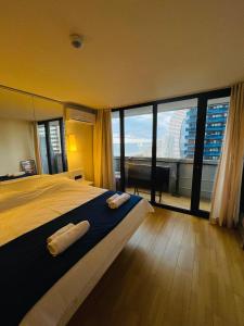 a bedroom with a large bed and large windows at Seaview-Studio Apartments in Orbi City in Batumi