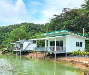 a house on the side of a body of water at บังกะโลบ้านสวนเอก Bungalow Baan Suan Aek in Ban Pang Chaphlung