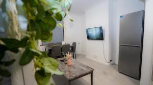 a room with a table and chairs and a refrigerator at Cozy 2 bed Apt with Private Garden in London