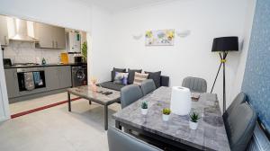 ein Wohnzimmer mit einem Esstisch und einer Küche in der Unterkunft Cozy 2 bed Apt with Private Garden in London