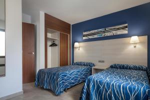 a hotel room with two beds and a mirror at Best Club Vacaciones Pueblo Indalo in Mojácar