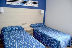 two beds in a room with blue and white sheets at Best Club Vacaciones Pueblo Indalo in Mojácar