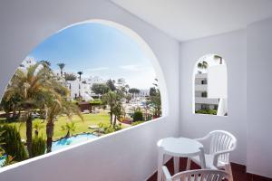a room with a view of the pool and palm trees at Best Club Vacaciones Pueblo Indalo in Mojácar