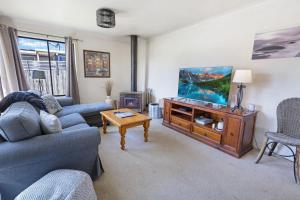 a living room with a couch and a flat screen tv at Katisha Cottage in Paynesville