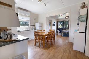 a kitchen and dining room with a table and chairs at Katisha Cottage in Paynesville