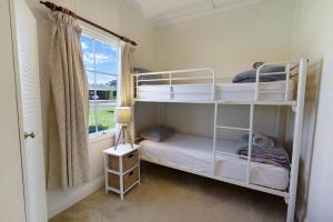 two bunk beds in a room with a window at Katisha Cottage in Paynesville