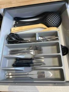 a drawer filled with silver utensils in a drawer at Studio proche de l’aéroport/gare/centre ville in Charleroi