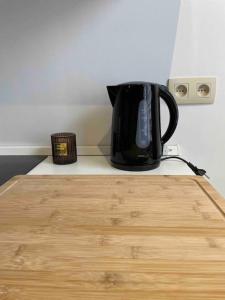 eine schwarze Kaffeekanne auf einer Theke in der Unterkunft Studio proche de l’aéroport/gare/centre ville in Charleroi