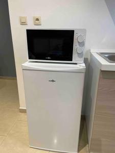a microwave sitting on top of a white refrigerator at Studio proche de l’aéroport/gare/centre ville in Charleroi