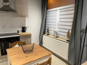 a kitchen with a wooden table and a window at Studio proche de l’aéroport/gare/centre ville in Charleroi