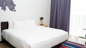 a bedroom with a white bed and a window at Aloft Ponce Hotel & Casino in Ponce